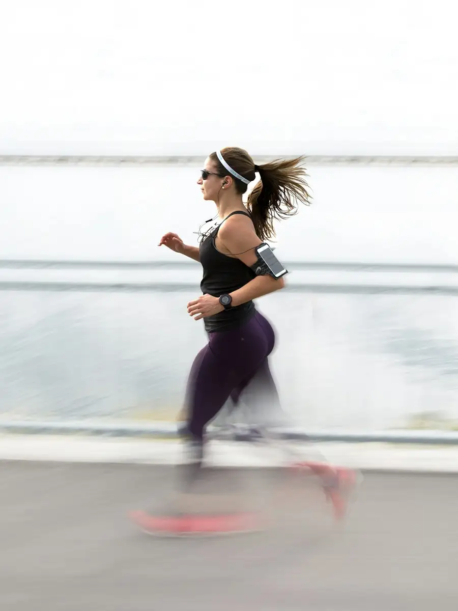 Woman running mid-stride along a seafront path